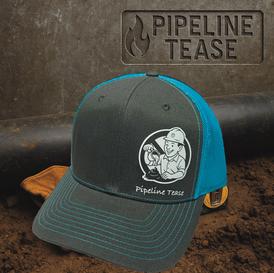  Dark grey and teal trucker hat featuring the Pipeline Tease white No Sugar Coating logo, displayed on a dirt jobsite background with Pipeline Tease branding.